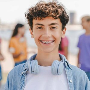 Authentic,Portrait,Of,Smiling,Teenage,Boy,With,Braces,Wearing,Headphones